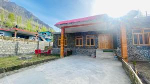 a small house with a red chair in front of it at Vantage Lodge in Skardu