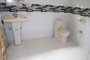 a bathroom with a toilet and a sink at Vantage Lodge in Skardu