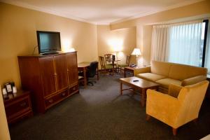 une chambre d'hôtel avec un canapé et une télévision dans l'établissement Hotel Mead Resorts & Conventions Center, à Wisconsin Rapids