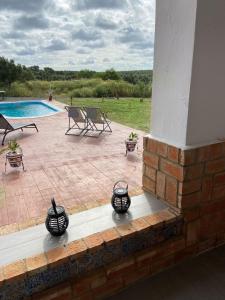 een patio met drie zwarte vazen naast een zwembad bij Hacienda Donaire Beas in Beas