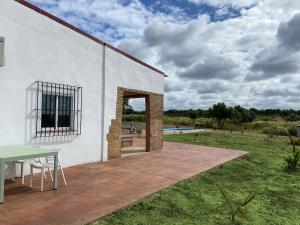 een wit gebouw met een patio met een tafel bij Hacienda Donaire Beas in Beas