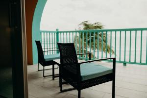 2 sillas y una mesa en el balcón en Grapetree Bay Hotel and Villas, en Christiansted