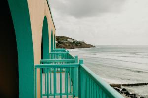 una barandilla verde en una playa con el océano en Grapetree Bay Hotel and Villas, en Christiansted