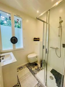een badkamer met een douche, een toilet en een wastafel bij Krystel Avel à La baule in La Baule
