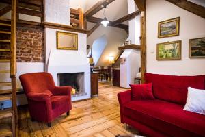 a living room with a red couch and a fireplace at Apartamenty Kamienica Muzyków Old Town Lublin in Lublin