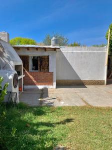una pequeña casa con una pared y un garaje en CASA DE LOS NONOS HOSPEDAJE en La Consulta