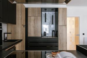 a kitchen with black cabinets and a window at Huswell - Stylish two bedroom apartment on top location in Middelkerke +32 photos