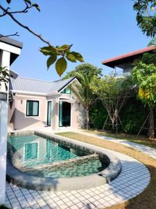 una piscina frente a una casa en BRAND-NEW! The Private PoolVilla /4BR byน้องมังคุด, en Nong Prue