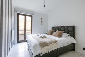 ein Schlafzimmer mit einem großen Bett und einem Fenster in der Unterkunft Stylish two bedroom apartment on top location in Middelkerke