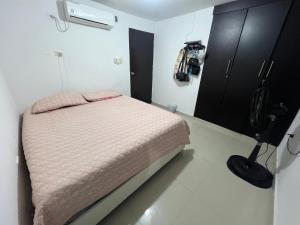 a small bedroom with a bed and a black cabinet at Apartamento festival vallenato in Valledupar