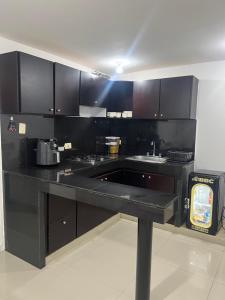 a kitchen with a black counter and a sink at Apartamento festival vallenato in Valledupar