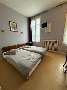 um quarto com 2 camas e uma televisão de ecrã plano em Aquanerius Résidence em Néris-les-Bains
