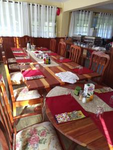 a dining room with long wooden tables and chairs at Sangare Gardens in Mweiga