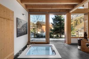 a hot tub in a room with a large window at Chalet Cinq Moutons in Orsières