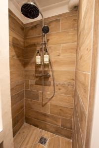 a bathroom with a shower with a wooden wall at Cosy Caud, appart en plein coeur du centre historique in Arles