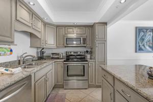 a kitchen with wooden cabinets and stainless steel appliances at FL-Seaspray Perdido Key 605 condo in Pensacola