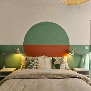 a bedroom with a bed with a green and red headboard at Casa di Marco in Irola