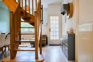 eine Küche und ein Wohnzimmer mit einer Holztreppe in der Unterkunft L'Emeraude - Les Demeures d'Adrien in Wasquehal