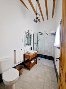La salle de bains est pourvue de toilettes, d'un lavabo et d'un miroir. dans l'établissement La Casa de la Rufi, à Colmenar de Oreja