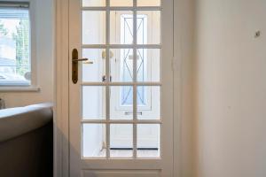 eine weiße Tür mit einem Fenster in einem Zimmer in der Unterkunft L'Emeraude - Les Demeures d'Adrien in Wasquehal
