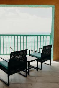 Duas cadeiras e uma mesa de vidro numa varanda em Grapetree Bay Hotel and Villas em Christiansted
