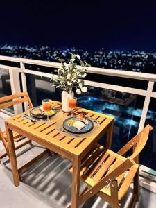 un tavolo in legno con cibo e bevande su un balcone di LuxeBali Azure @ Azure North a San Fernando