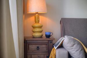 コティージョにあるEl Cotillo Central Apartment with two bedroomsの椅子の横のテーブルに座るランプ