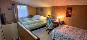 um pequeno quarto com 2 camas e uma janela em Cabañas Los Geranios em Osorno