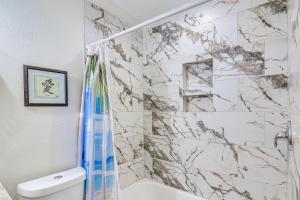 ein Bad mit einer Dusche und einer Marmorwand in der Unterkunft Walk to Beach and Moody Mansion Galveston Home! in Galveston + 17 Fotos