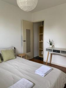 a bedroom with a bed with two towels on it at JIYARA F3 PROCHE CENTRE Ville in Belfort