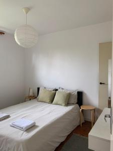 een slaapkamer met een groot wit bed en een hanglamp bij JIYARA PROCHE CENTRE Ville in Belfort