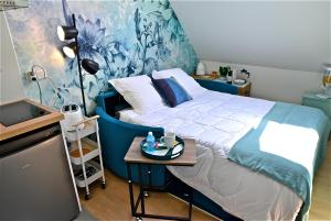 a bedroom with a bed with a blue headboard and a table at Studio, centre ville, tout confort, local vélo in Amiens