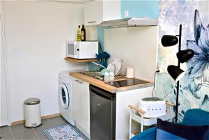 a kitchen with a sink and a washing machine at Studio, centre ville, tout confort, local vélo in Amiens