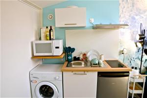 a small kitchen with a sink and a microwave at Studio, centre ville, tout confort, local vélo in Amiens