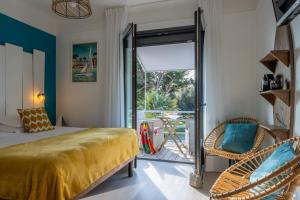 um quarto com uma cama e uma porta de vidro deslizante em Hotel La Roseraie em Fouras