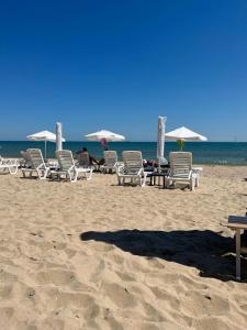 a group of chairs and umbrellas on a beach at Peter Apartmanbulgaria-Imperial Fort Noks in Elenite