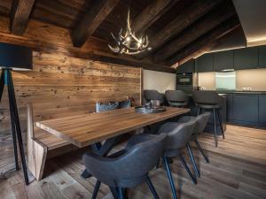 瓦爾特的住宿－AlpenParks Hotel & Apartment Arlberg Warth mit Pool，一间带木桌和椅子的用餐室