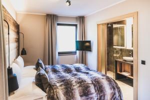 a hotel room with a bed and a shower at AlpenParks Hotel & Apartment Arlberg Warth mit Pool in Warth am Arlberg