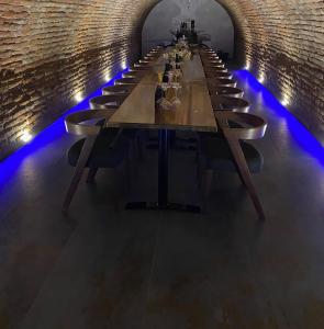 einen langen Tisch in einem Tunnel mit blauen Lichtern in der Unterkunft Studio apartman & Wine House ONDINE in Zmajevac