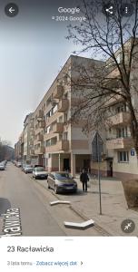 a person standing on a street next to a building at APARTAMENT PARKOWY UL. RACLAWICKA in Krakow