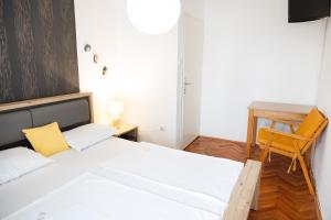 a bedroom with a bed and a desk and a chair at Apartmani Novkovic in Bar