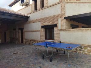 a blue ping pong table in front of a building at Casas Rurales El Aljibe, Jara in Argés