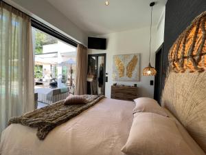 a bedroom with a large bed and a large window at Superbe Villa très proche cannes in Mougins