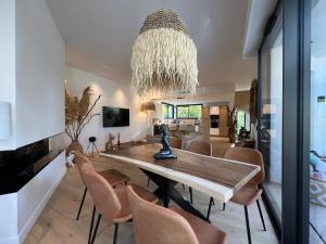a dining room with a table and chairs and a chandelier at Superbe Villa très proche cannes in Mougins