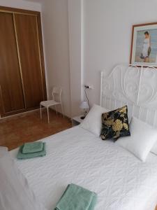 a bedroom with a white bed with two pillows at Lodosol in Lo Pagán