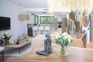a living room with a table with a vase of flowers at Superbe Villa très proche cannes in Mougins