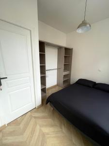 1 dormitorio con cama negra y armario en DUPLEIX PARISIEN, en Vanves