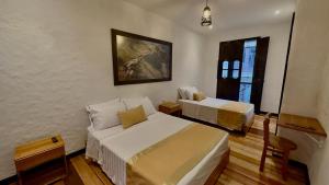 ein Schlafzimmer mit 2 Betten und einem Wandgemälde in der Unterkunft Hotel Boutique La Leyenda 1860 in Salamina