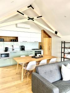 a kitchen and dining room with a table and a couch at Aspiring View Apartments in Wanaka