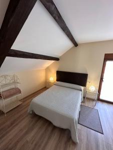 1 dormitorio con cama blanca y ventana en Casa Bieiteiro, en Valdoviño